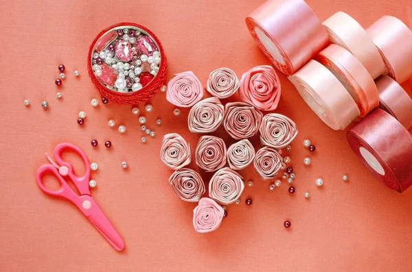Adım adım talimat. Rosette saten kurdeleden yapılmış. El yapımı el sanatları. Şeftali arkaplan. Pembe renkler, pembe kurdeleler. Yaratılış. Kurdeleden, kumaştan çiçekler. 