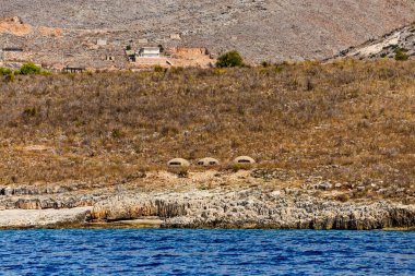Arnavutluk 'un güneyinde Saranda kasabası yakınlarındaki İyon Denizi kıyısında Enver Hoca' nın komünist hükümeti tarafından inşa edilmiş sayısız askeri sığınak veya sığınak. Sığınak batıya döndü..