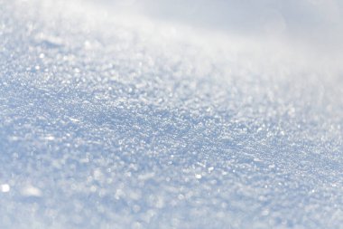 Işıl ışıl beyaz karın makro fotoğraf dokusunu açık mavi gökyüzü yansıtma tonuyla kapatın. Seçici odaklanma. Kış Noel arkaplanı.