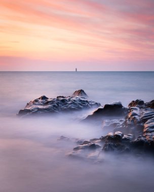 Gün batımında Guernsey 'deki deniz manzarasının uzun pozu.