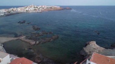 Akdeniz kıyılarındaki bazı kayalıklarda bir balıkçının hava görüntüsü, insansız hava aracı deniz üzerinde dairesel bir hareket yapar, Cabo de Palos deniz fenerini ve Manga del Mar Menor 'u görürüz.