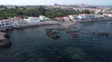 Bir balıkçının kıyı kasabasının kayalıklarında denizden kamış topladığını gördük. Birkaç ev ve arkamızda ağaçlık bir alan gördük.