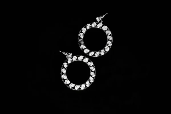 Boucles d'oreilles rondes en argent avec des bijoux sur le fond noir. Mode — Photo