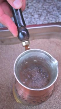 Türk kahvesinin kumda hazırlanışının dikey videosu. Türk kahve kavramı