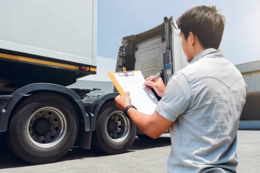 Kamyon Şoförü, Kamyonun Güvenlik Bakım Listesini kontrol ediyor. - Lorry. Teftiş Kamyonu Güvenlik Yarı Kamyon Tekerlekleri ve Lastikleri. Nakliye Kargo Taşımacılığı Lojistiği.