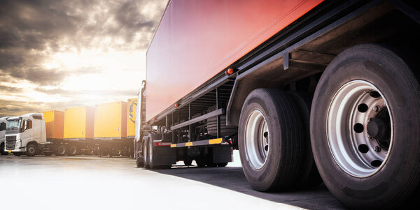 Semi Trailer Trucks Parking lot at The Sunset Sky. Shipping Cargo Container. Truck Wheels Tires. Industry Freight Truck Logistics Cargo Transport.