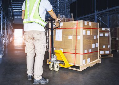 Depo işçisi, El Paleti Krikosu 'nu paket kutusuyla boşaltıyor. Depo Deposunda Malzeme Zinciri Kargo Deposu Lojistiği.