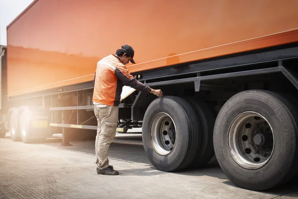 Kamyon Şoförü, Kamyonun Güvenlik Bakım Listesini kontrol ediyor. - Lorry. Yarı Kamyon Tekerlekleri ve Lastikleri İnceleme. Nakliye Aracı Taşımacılığı.