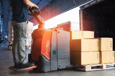 Forklift Palet 'i kullanan işçiler, Jack' in liman deposundaki kargo konteynırına ambalaj kutuları yüklemesi. Teslimat servisi. Depo Lojistiği sevkiyatı. Kargo Sevkiyatı. Nakliye Aracı Taşımacılığı.