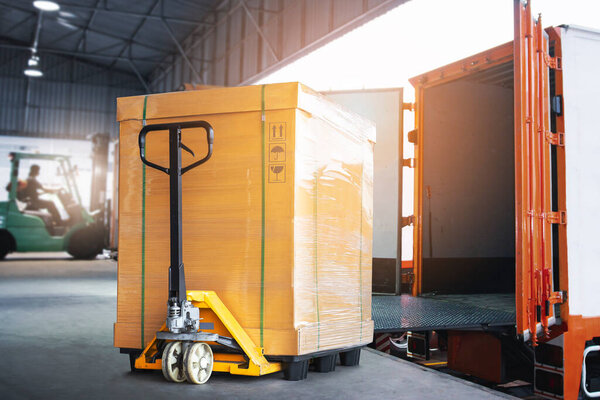 Packaging Boxes with Hand Pallet Truck Loading into Shipping Cargo Container. Delivery Trucks Parked Loading at Dock Warehouse. Supply Chain Customers Shipment Logistics. Cargo Freight Truck Transport.