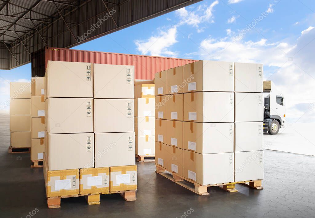 Packaging Boxes Stacked on Pallets Loading into Shipping Cargo Container. Delivery Trucks Parked Loading at Dock Warehouse. Supply Chain Customers Shipment Logistics. Cargo Freight Truck Transport