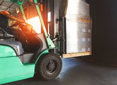 Forklift traktör yükleme kutuları liman deposundaki kargo konteynırına yükleniyor. Teslimat servisi. Depo Lojistiği sevkiyatı. Kargo Sevkiyatı. Nakliye Aracı Taşımacılığı.