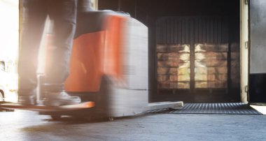 Elektrik Forklift kullanan işçilerin hareket bulanıklığı konteynırın içindeki paketlerin boşaltılmasına neden oluyor. Nakliye Kargo Dağıtım Deposu