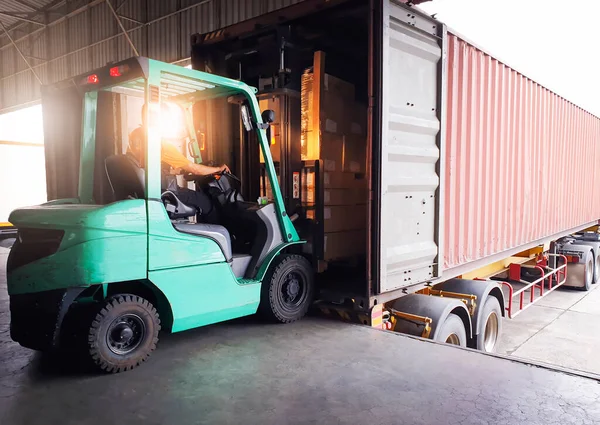 Forklift traktör yükleme kutuları liman deposundaki kargo konteynırına yükleniyor. Teslimat servisi. Depo Lojistiği sevkiyatı. Kargo Sevkiyatı. Nakliye Aracı Taşımacılığı.