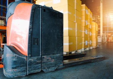 Depoda ambalaj kutuları olan elektrikli forklift paleti. Kargo Malzeme Kutuları. Tedarik zinciri. Nakliye Deposu Kargo İthalatı - Aktarım.