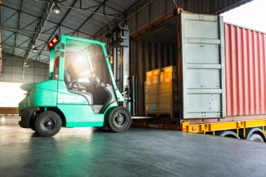 Forklift Traktörü, liman deposundaki konteynıra yükleme yapıyor. Teslimat Kargo Kamyonları Servisi. Depo Lojistiği. Nakliye Nakliye Aracı Taşımacılığı.