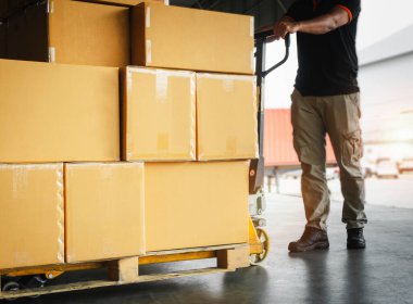 Paletlere Yığılmış Paket Kutuları. Karton Malzeme Kutuları. İşçiler depoya karton ürün boşaltıyorlar. Tedarik zinciri. Nakliye Deposu Lojistiği.