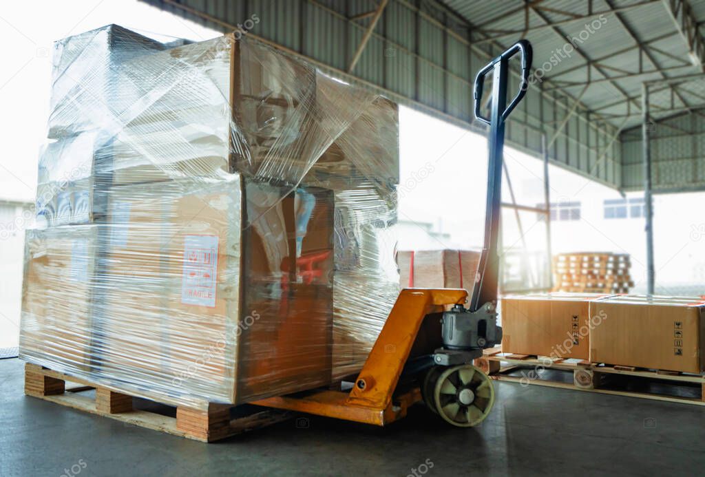 Packaging Boxes Wrapped Plastic Film on Pallets Rack with Hand Pallet Truck. Supply Chain Goods. Storehouse Commerce Shipment. Shipping Warehouse Logistics.