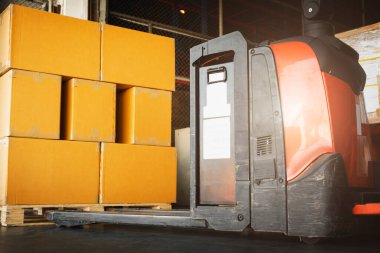Electric Forklift Pallet Jack with Packaging Boxes on Pallet in Distribution Warehouse. Shipment Goods Boxes. Supply Chain. Shipping Warehouse Logistics.
