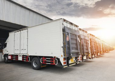 Kargo konteynır kamyonları Sunset 'le birlikte Dağıtım Deposu' na park etmiş. Nakliye konteynırı kaldırma kamyonları. - Lorry. Kargo Nakliye Kamyonları Lojistik TaşımacısıName.