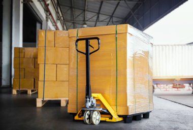 Packaging Boxes Wrapped Plastic on Pallets with Hand Pallet Truck. Shipping Warehouse Cargo Shipment. Supplies. Distribution Warehouse Logistics.