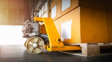 Paletler üzerinde paketleme kutuları olan El Paleti Kamyonu. Dağıtım Deposu. Kargo Sevkiyatı. Malzemeler Depo Lojistiği.