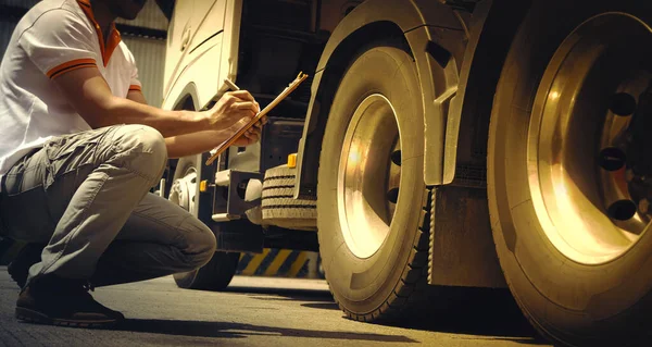 Auto Mechanic is Checking the Truck\'s Safety Maintenance Checklist. Inspection Safety of Semi Truck Wheels Tires.