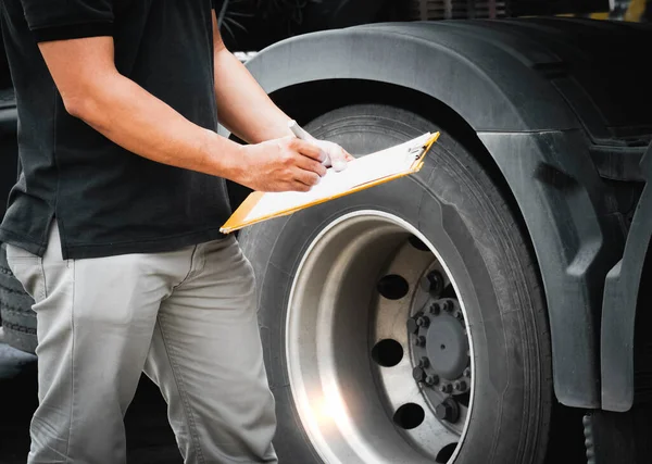 Auto Mechanic is Checking the Truck\'s Safety Maintenance Checklist. Inspection Safety of Semi Truck Wheels Tires.