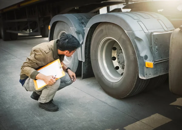 Auto Mechanic is Checking the Truck\'s Safety Maintenance Checklist. Inspection Safety of Semi Truck Wheels Tires.
