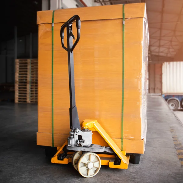 Hand Pallet Truck with Packaging Boxes Stacked on Plastic Pallet. Supply Chain. Cargo Shipment Boxes. Distribution. Supplies Warehouse Logistics.