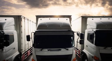 Kargo kamyonları Sunset Sky 'la park etmiş. Nakliye kamyonları. Teslimat Transit. Motor Diesel Trucks. Endüstriyel Yük Kamyonları Lojistik Taşımacılık.