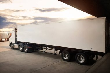 Yarı karavan kamyonları rıhtım deposuna parketmiş. Kargo konteynırı nakliye kamyonları. Dağıtım Deposu. Yük Kamyonları Kargo Taşımacılığı. Depo Lojistiği.