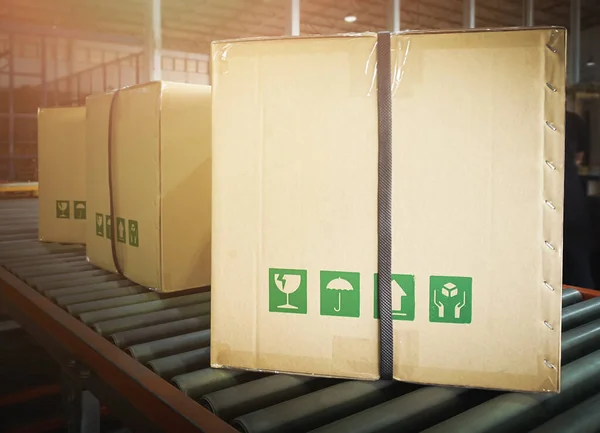 Packaging Boxes Moving on Conveyor Belt. Cartons, Cardboard Boxes. Storehouse. Distribution Warehouse. Shipping Supplies Warehouse. Cargo Shipment.