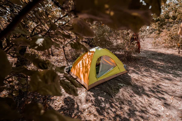 Uma tenda fica no meio de uma clareira florestal deserta no outono. Caminhada de outono. — Fotografia de Stock