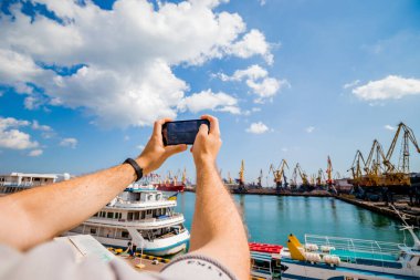 Bir turist telefonda deniz terminalinin fotoğraflarını çekiyor.. 