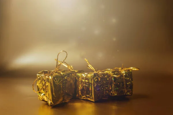 Fondo de oro de Navidad con regalos en envases de oro. — Foto de Stock