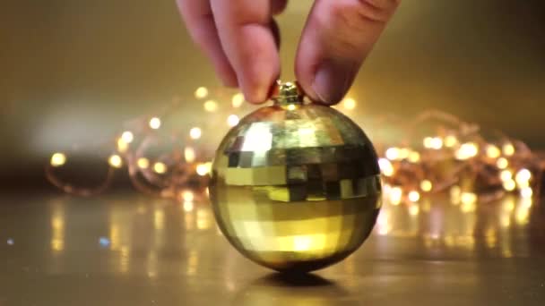 Küçük altın bir disko topu altın bir Noel arka planında dönüyor.. — Stok video