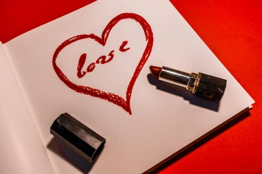 Kırmızılı bir arkaplanda beyaz bir çarşafa ruj sürülmüş..