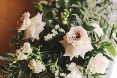 Parlak, güzel, toplanmış gelin buketi masanın üstünde..