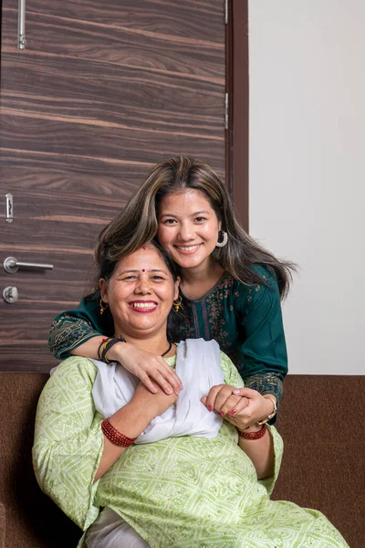 Cute young indian daughter embracing her mother with love. Mother's day love family and parenthood concept. Mother and daughter enjoying their time together at home.