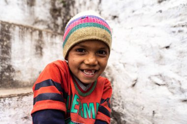 Almora, Uttarakhand - January 4 2022- A portrait of an indian kid smiling into the camera. Indian kid wearing a cap.