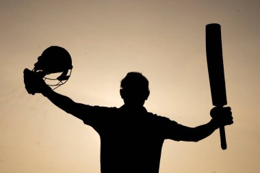 Kriket maçında bir yüzyıl geçirdikten sonra kutlama yapan bir kriket oyuncusunun silueti. Hint kriket oyuncuları ve spor konsepti.
