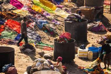 Agra, Uttar Pradesh - 28 Ocak 2022 - Tabanlı bir dhobi ghatının havadan görünüşü. Dhobi ghat zemininde uzanan renkli kıyafetler..