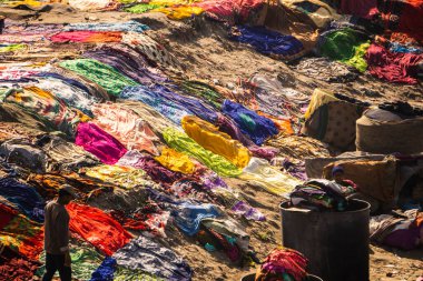 Agra, Uttar Pradesh - 28 Ocak 2022 - Tabanlı bir dhobi ghatının havadan görünüşü. Dhobi ghat zemininde uzanan renkli kıyafetler..