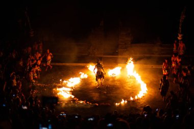 Bali - Indonesia - 10.21.2015: Kecak dancers performing the Fire Dance in the Pura Luhur Uluwatu amphitheater, Uluwatu Temple a Balinese Hindu sea temple on the hill