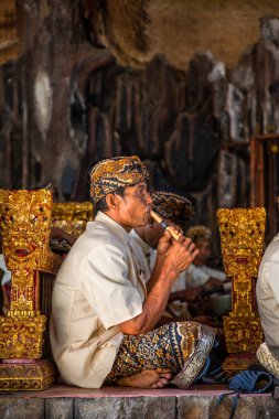 Bali - Endonezya - 10.22.2015: Endonezyalı genç adam geleneksel giysiler içinde dikey bambu flüt çalıyor