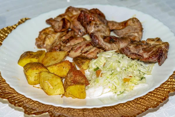 Kızarmış patatesli tavuk bifteği ve beyaz tabakta lahana