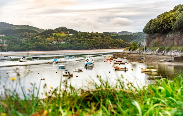 Etrafı dağlarla dolu Bilbao sahilinin güzel manzarası, kıyıda dinlenen bazı tekneler var.