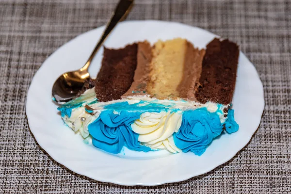 yanında çay kaşığı ile birlikte gri arka planda mavi ve beyaz kek tabağı.