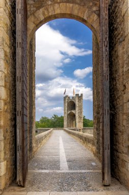 Besalu, İspanya, eski geçitli ortaçağ taş köprüsü, kemerli kapıdan kulenin manzarası. 
